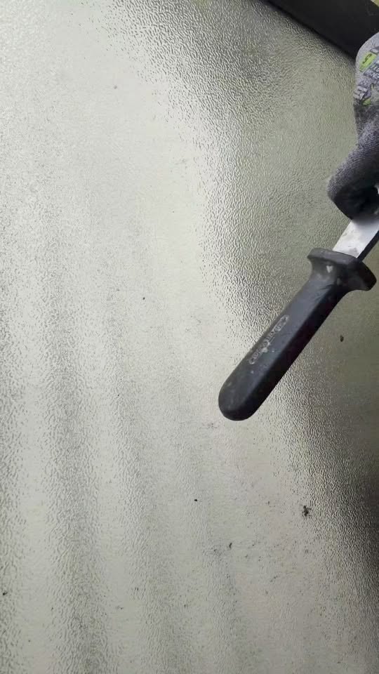 Close up of patterned obscure glass being cut